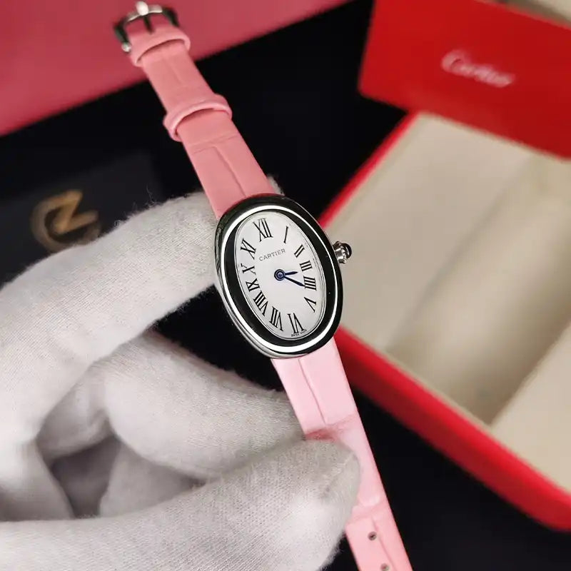 Montre ovale argentée à cadran clair et bracelet rose tenue avec un gant