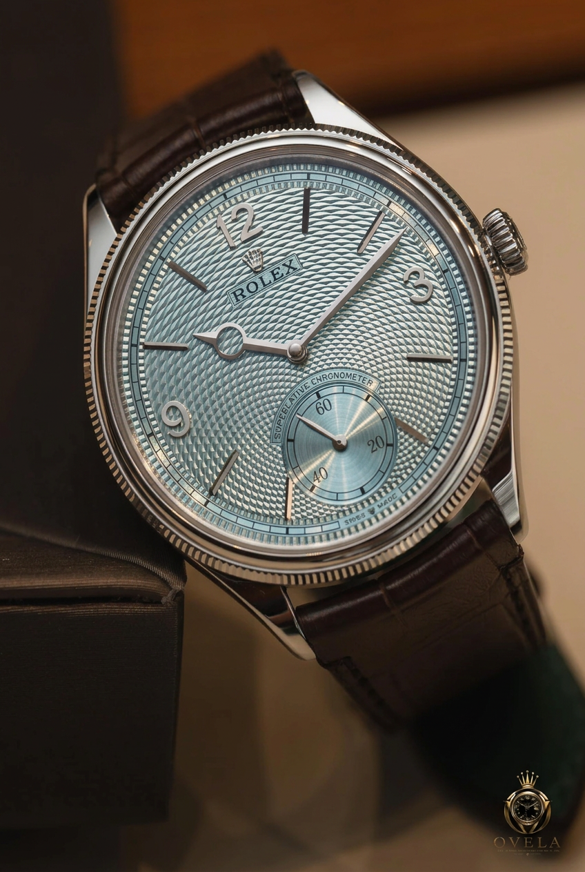 Montre à cadran bleu glacier et bracelet brun, logo OVELA en bas à droite