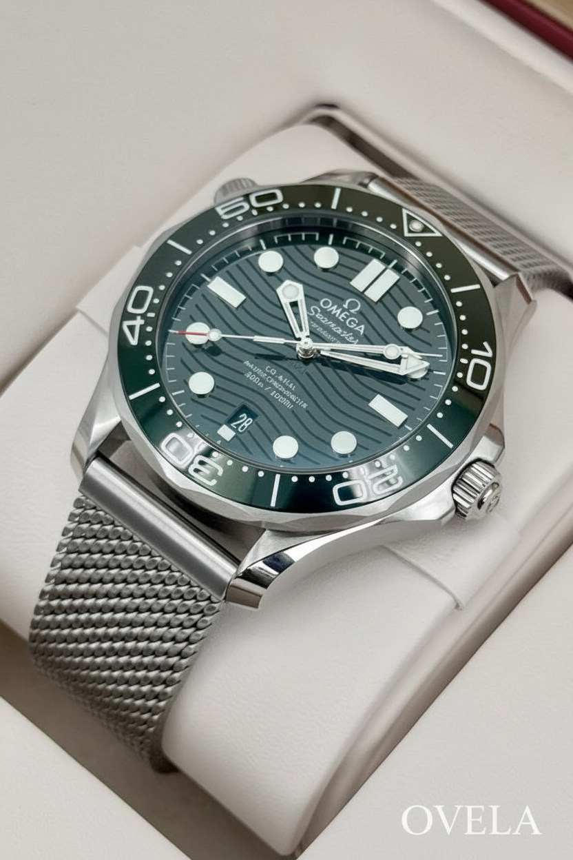 Montre Omega Seamaster verte avec logo OVELA posée sur un coussin blanc